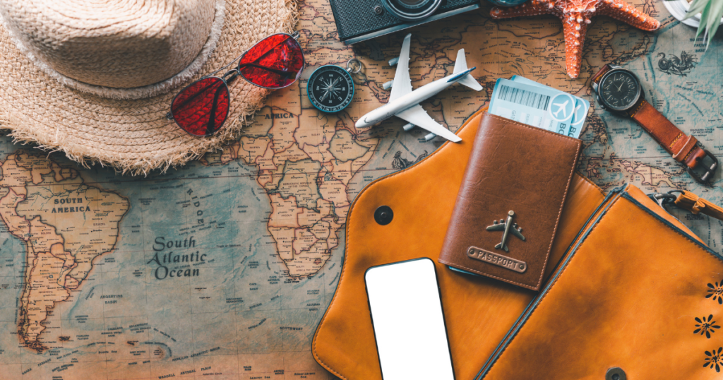 Travel essentials on world map including passport, phone, and accessories representing hotel safety tips Las Vegas and travel safety awareness routines