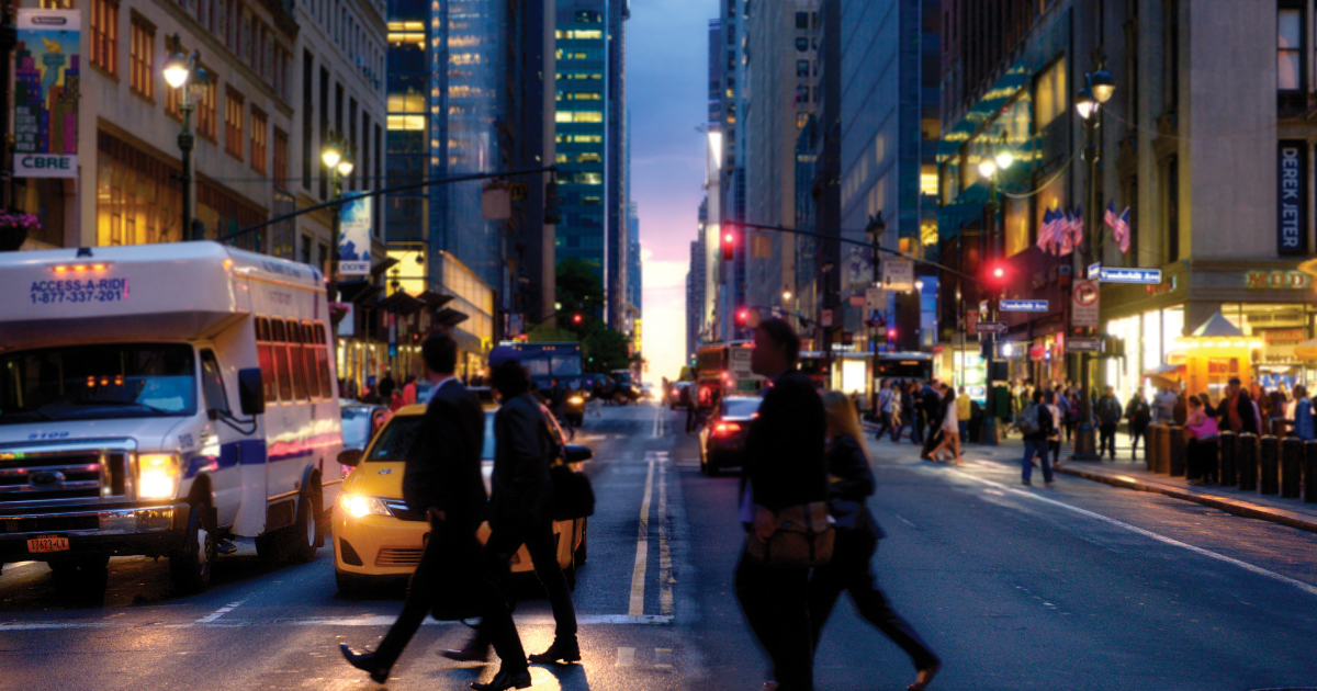 Busy city street at dusk with pedestrians and traffic, representing personal safety awareness and situational awareness tips for everyday life in urban environments